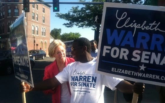 Senator Cory Booker laughing with two campaign leaders and advisors